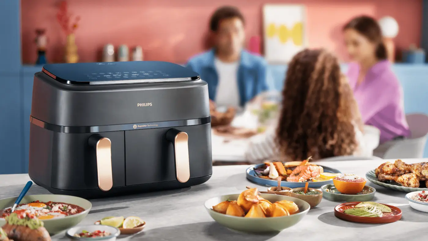Philips Dual Basket airfryer on a kitchen worktop with a number of dishes prepared in it Philips Dual Basket airfryer on a kitchen worktop with a number of dishes prepared in it