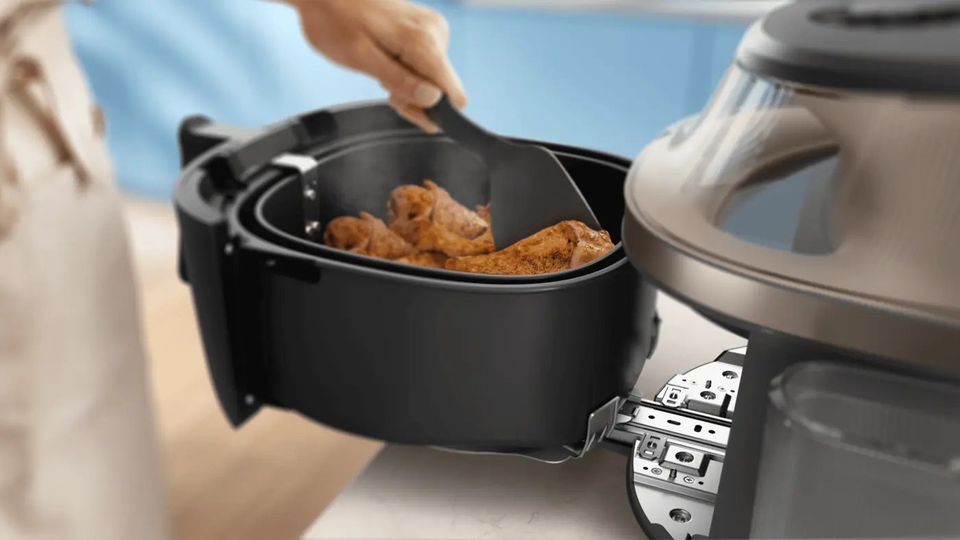 De mand steunt op de EasySlide rail, zo schuift hij makkelijk en veilig in en uit de Airfryer. De mand steunt op de EasySlide rail, zo schuift hij makkelijk en veilig in en uit de Airfryer.