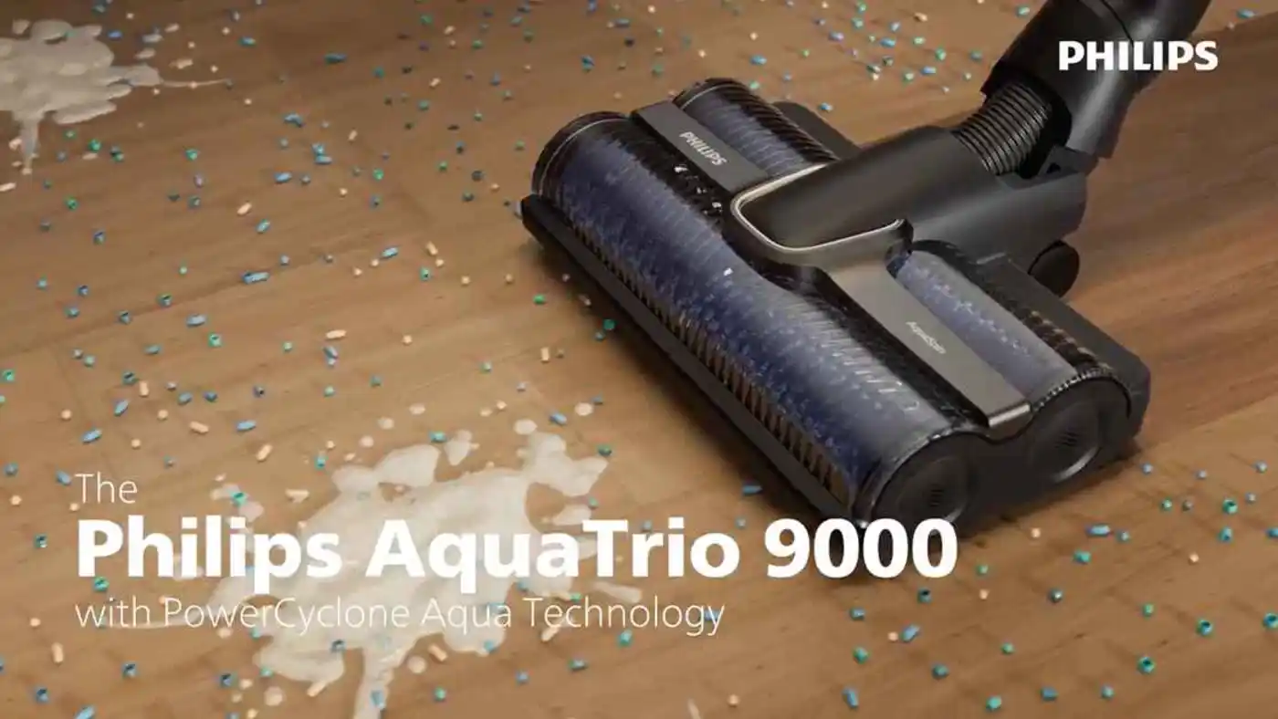 Philips AquaTrio 9000: Vezeték nélküli porszívó egy modern nappaliban, elegáns dizájn kiegészíti a kortárs bútorokat és a világos, levegős teret. Philips AquaTrio 9000: Vezeték nélküli porszívó egy modern nappaliban, elegáns dizájn kiegészíti a kortárs bútorokat és a világos, levegős teret.