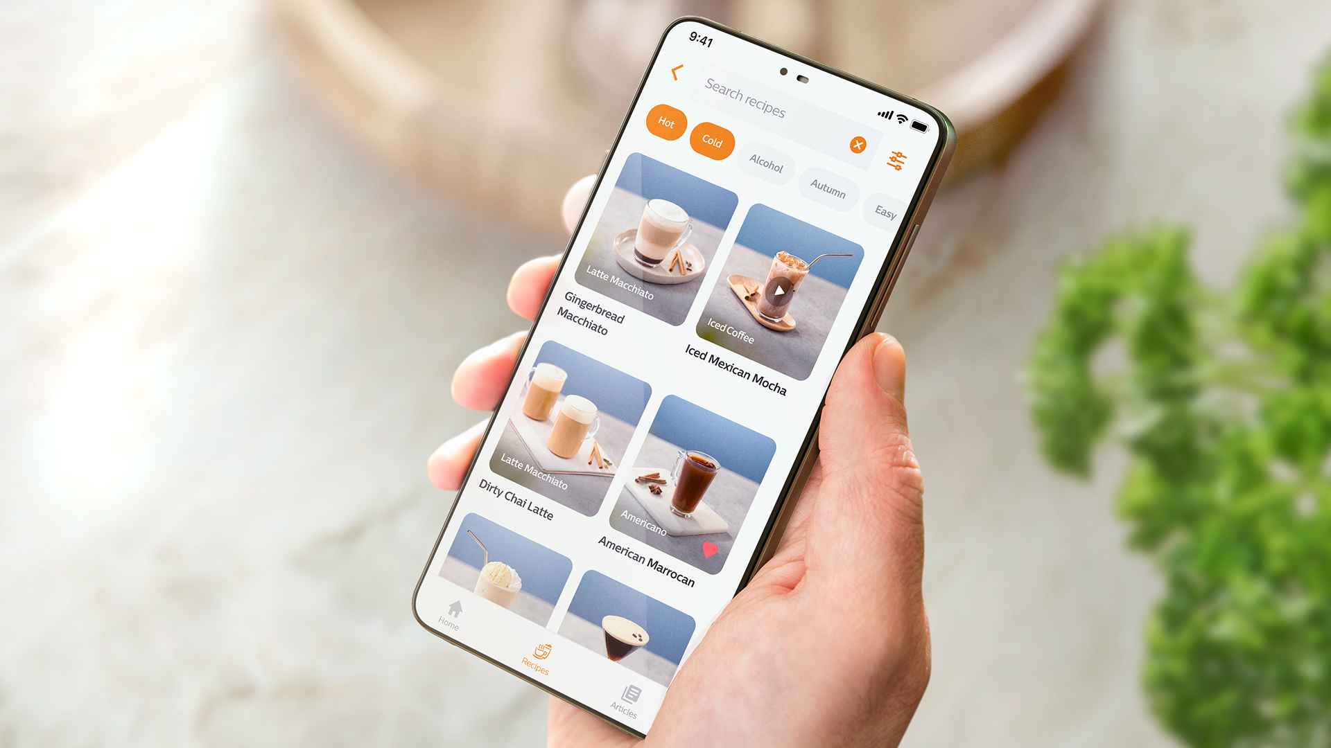 Henkilö, joka pitelee puhelinta, jossa näkyy Philips Baristina -sovelluksen käyttöliittymä ja esittelee kuratoituja kahvireseptejä, kuten latte macchiato ja jääkahvi, suodatinvaihtoehdoilla premium-käyttökokemusta varten. Henkilö, joka pitelee puhelinta, jossa näkyy Philips Baristina -sovelluksen käyttöliittymä ja esittelee kuratoituja kahvireseptejä, kuten latte macchiato ja jääkahvi, suodatinvaihtoehdoilla premium-käyttökokemusta varten.