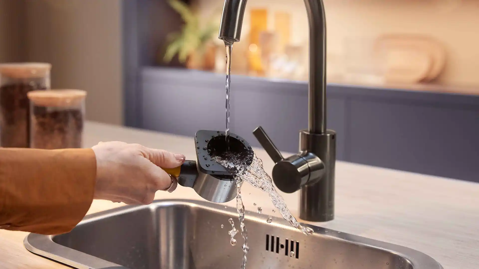 Persoană clătind zațul de cafea dintr-un portafiltru Philips Baristina sub un robinet. Curățare ușoară a espressorului premium în chiuveta modernă. Persoană clătind zațul de cafea dintr-un portafiltru Philips Baristina sub un robinet. Curățare ușoară a espressorului premium în chiuveta modernă.