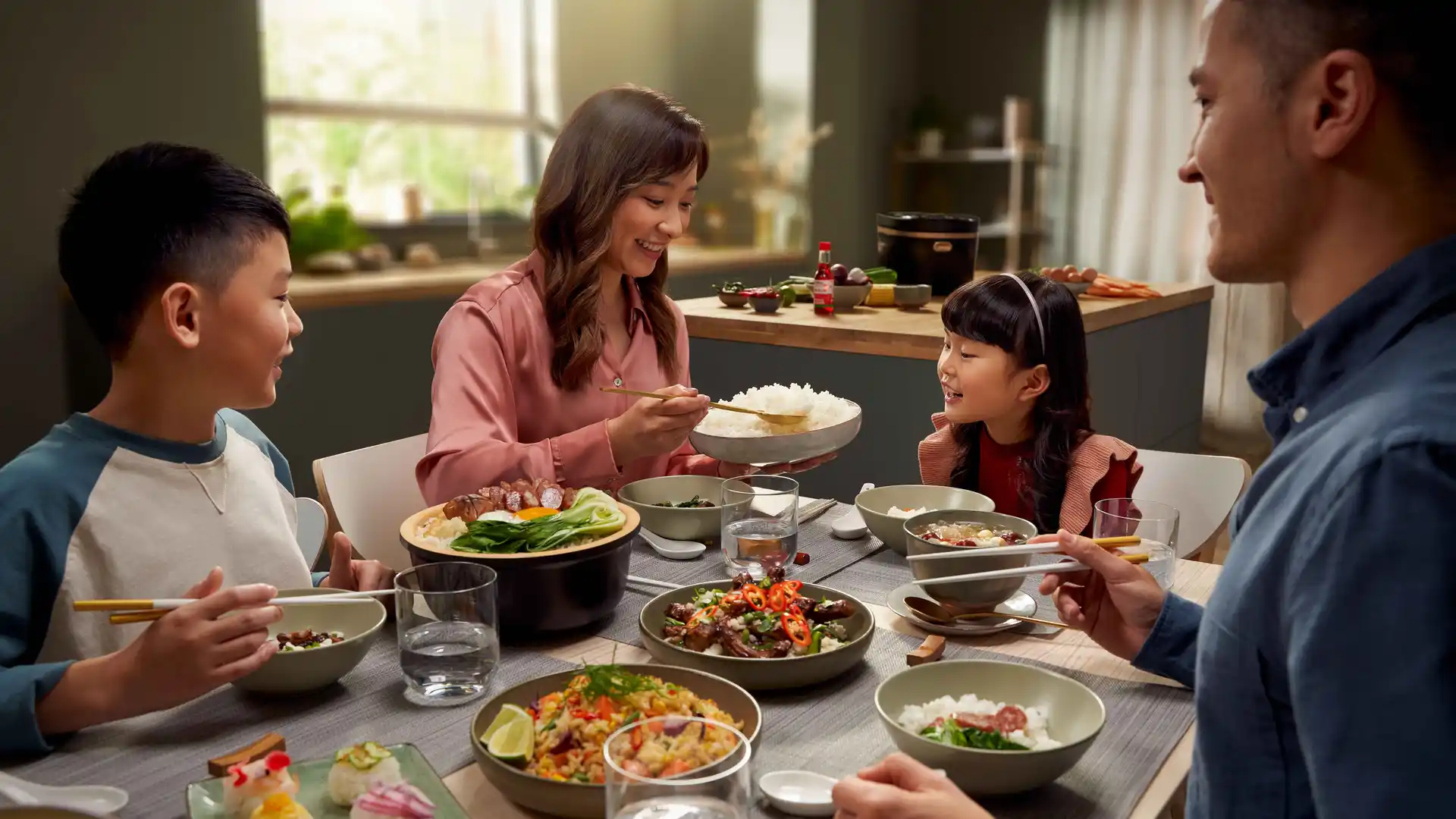 De familie geniet van een verscheidenheid aan Aziatische gerechten, bereid met Philips-kooktoestellen. Rijstkoker uitgestald op een tafel gedekt voor een familiediner. De familie geniet van een verscheidenheid aan Aziatische gerechten, bereid met Philips-kooktoestellen. Rijstkoker uitgestald op een tafel gedekt voor een familiediner.