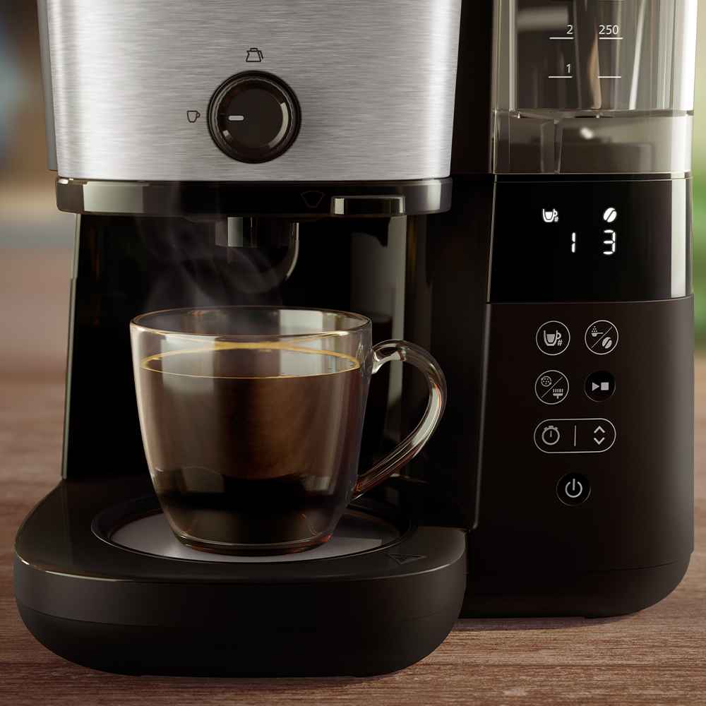Nahaufnahme einer Philips Filterkaffeemaschine mit einer klaren Tasse, die das Brühen von Kaffee, den digitalen Timer und die Warmhalteplatte hervorhebt. Dies unterstreicht das reiche Aroma. Nahaufnahme einer Philips Filterkaffeemaschine mit einer klaren Tasse, die das Brühen von Kaffee, den digitalen Timer und die Warmhalteplatte hervorhebt. Dies unterstreicht das reiche Aroma.