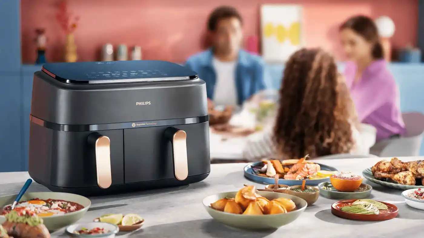 Philips Dual Basket Airfryer ve stylové šedé barvě, prezentován v moderní kuchyni. Vlastnosti: technologie RapidAir, nastavení rodinného jídla, uživatelsky přívětivé dotykové ovládání. Philips Dual Basket Airfryer ve stylové šedé barvě, prezentován v moderní kuchyni. Vlastnosti: technologie RapidAir, nastavení rodinného jídla, uživatelsky přívětivé dotykové ovládání.