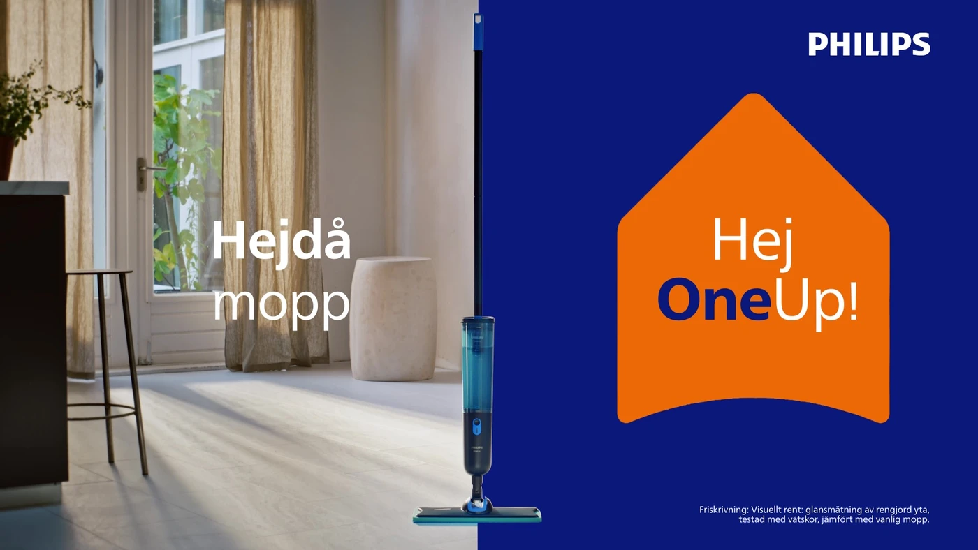 Philips OneUp – kampanjbild med texten "Hejdå mopp, Hej OneUp!" En blå spraymopp står i ett ljust vardagsrum bredvid fönster med beiga gardiner. Philips OneUp – kampanjbild med texten "Hejdå mopp, Hej OneUp!" En blå spraymopp står i ett ljust vardagsrum bredvid fönster med beiga gardiner.