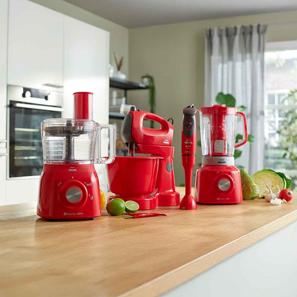 Philips Food Prep -sarja: ensiluokkainen punainen yleiskone (650 W), sähkövatkain, sauvasekoitin ja tehosekoitinsarja puisella työtasolla valoisassa keittiössä. Keittiön ruoanlaiton huippuosaamista. Philips Food Prep -sarja: ensiluokkainen punainen yleiskone (650 W), sähkövatkain, sauvasekoitin ja tehosekoitinsarja puisella työtasolla valoisassa keittiössä. Keittiön ruoanlaiton huippuosaamista.