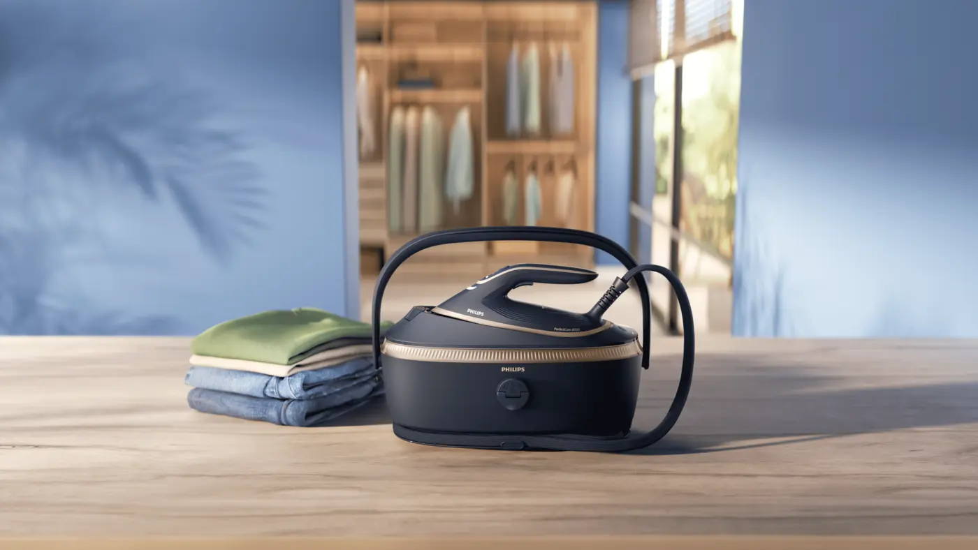 Philips PerfectCare 8000 generatore di vapore con vestiti su tavolo in legno in una moderna lavanderia. Philips PerfectCare 8000 generatore di vapore con vestiti su tavolo in legno in una moderna lavanderia.