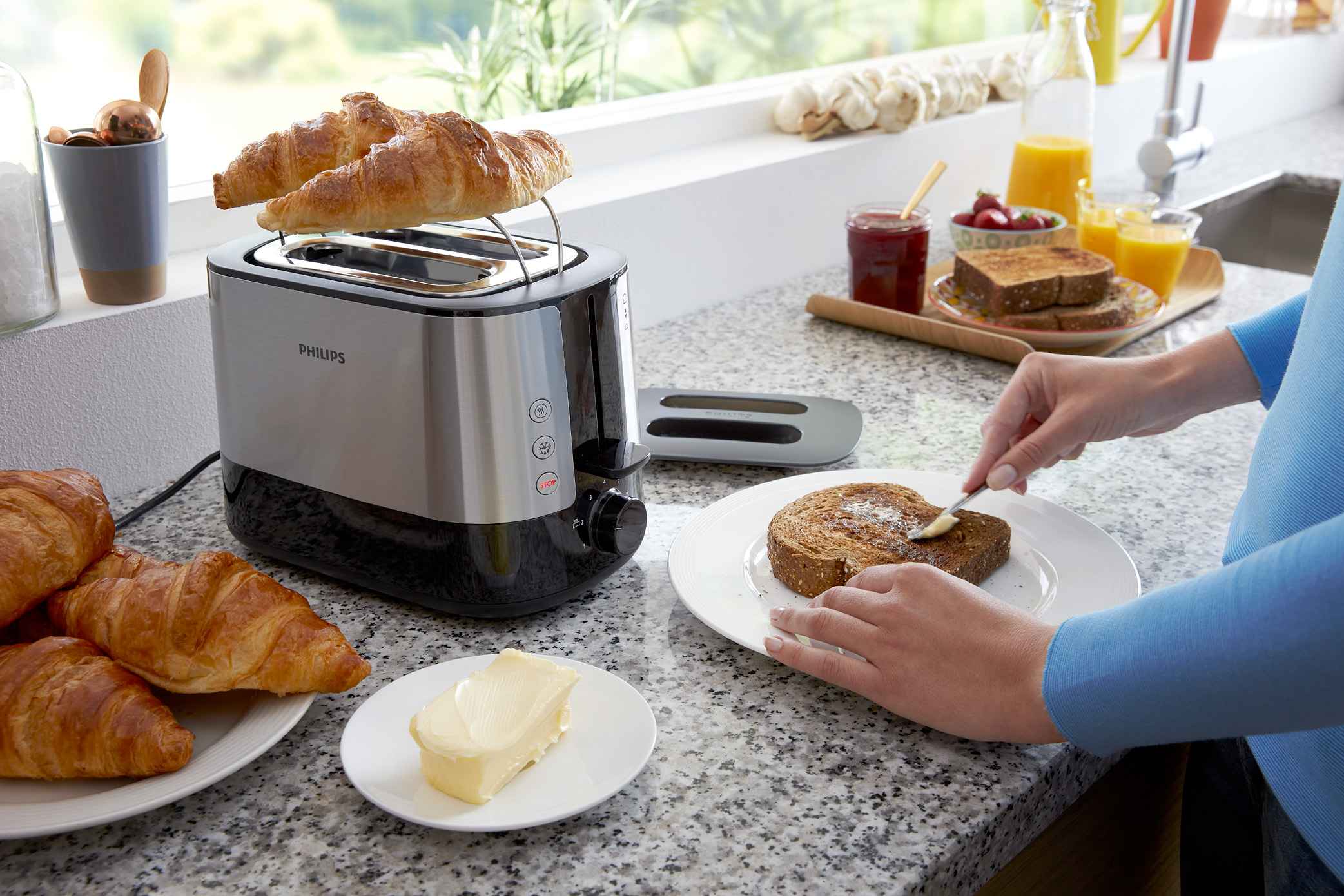 Philips utvalg av griller og brødristere presenterer en toskivs premiumbrødrister i moderne kjøkken. Croissanter ristes, som understreker brukervennlighet, med frokostbord med appelsinjuice, smør og syltetøy for perfekte morgner Philips utvalg av griller og brødristere presenterer en toskivs premiumbrødrister i moderne kjøkken. Croissanter ristes, som understreker brukervennlighet, med frokostbord med appelsinjuice, smør og syltetøy for perfekte morgner
