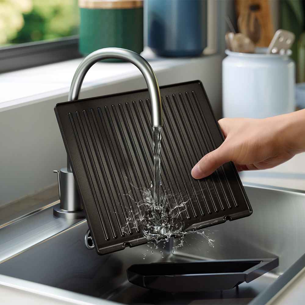 Philips Grillar & brödrostar: grillplattan diskas i en modern diskho. Illustrerar enkel rengöring, avtagbar droppbricka och högkvalitativ design. Philips Grillar & brödrostar: grillplattan diskas i en modern diskho. Illustrerar enkel rengöring, avtagbar droppbricka och högkvalitativ design.