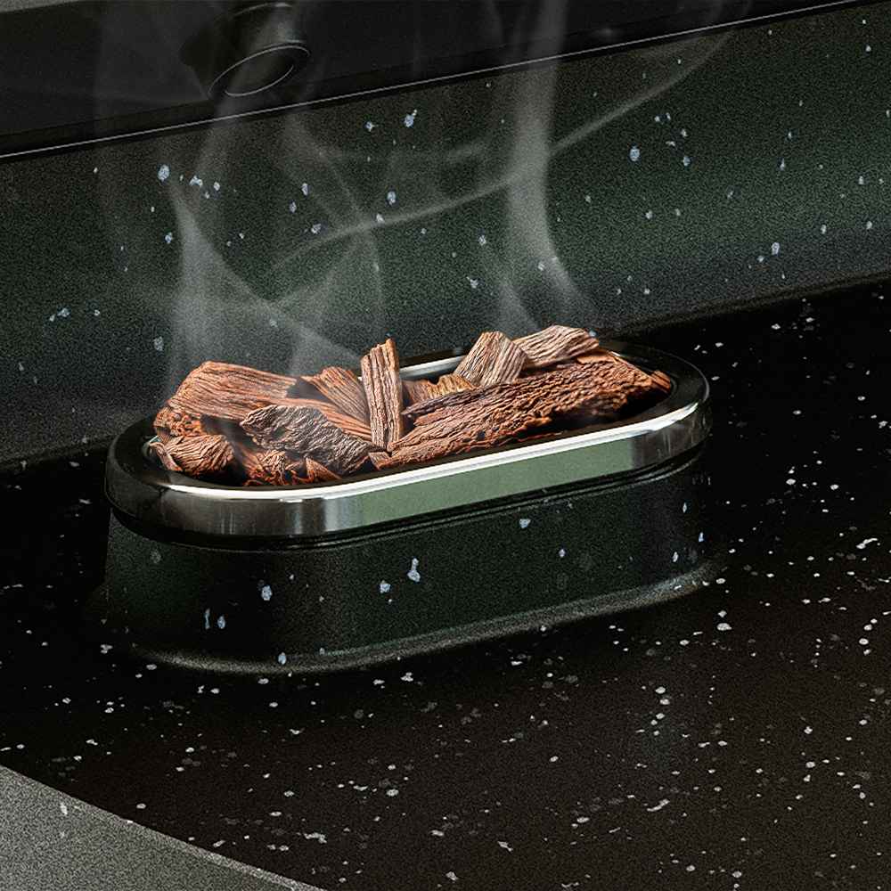Lähikuva savuavista puulastuista Philips Grills & toasters -soikeassa tarjottimessa, korostaen innovatiivista savustusominaisuutta. Lähikuva savuavista puulastuista Philips Grills & toasters -soikeassa tarjottimessa, korostaen innovatiivista savustusominaisuutta.