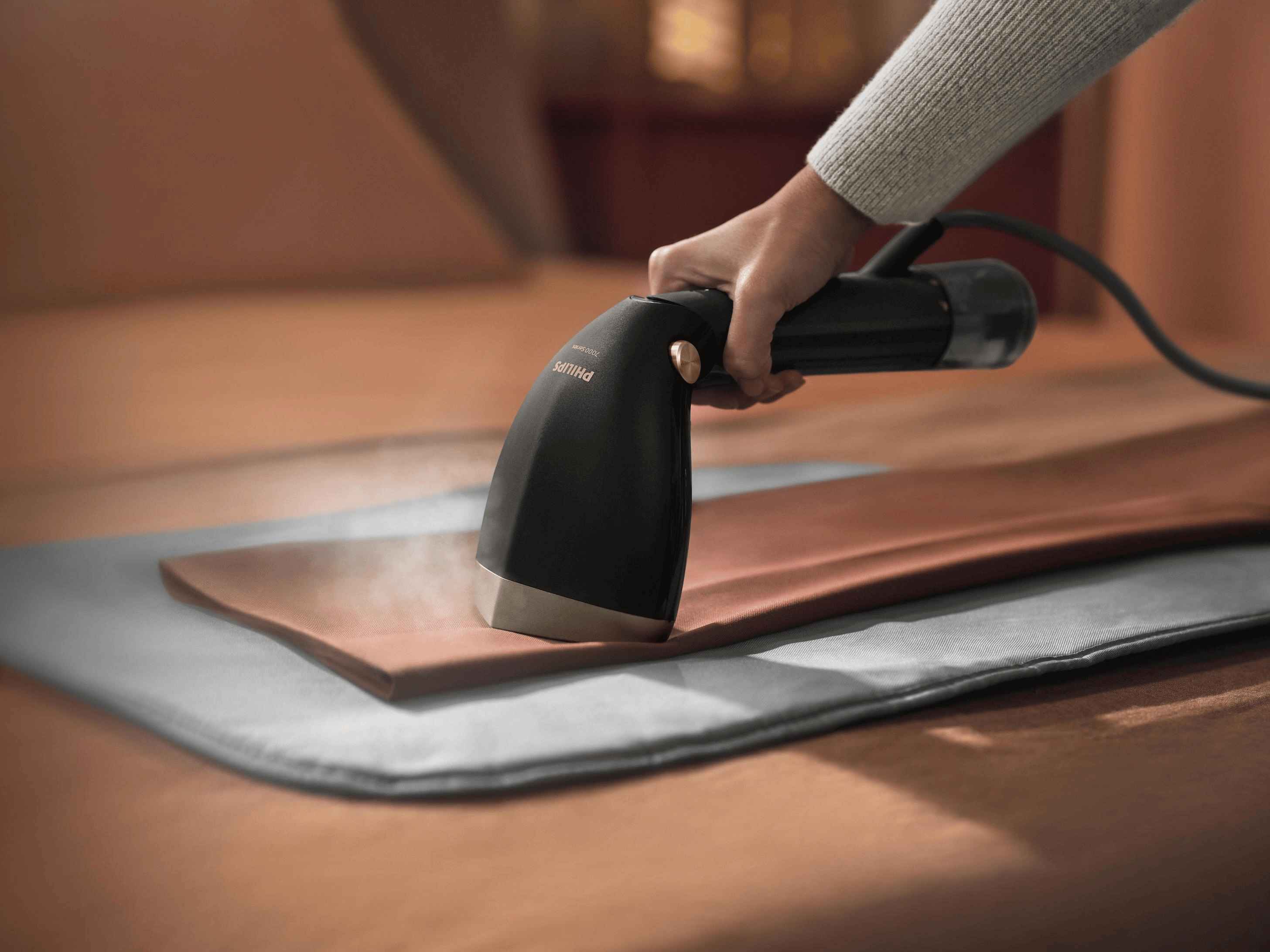 Philips Handdampfglätter: Dampfglätter der 7000er Serie wird auf Stoff verwendet, Dampf entfernt sichtbar Falten. Verbesserte Textilpflegelösung. Philips Handdampfglätter: Dampfglätter der 7000er Serie wird auf Stoff verwendet, Dampf entfernt sichtbar Falten. Verbesserte Textilpflegelösung.