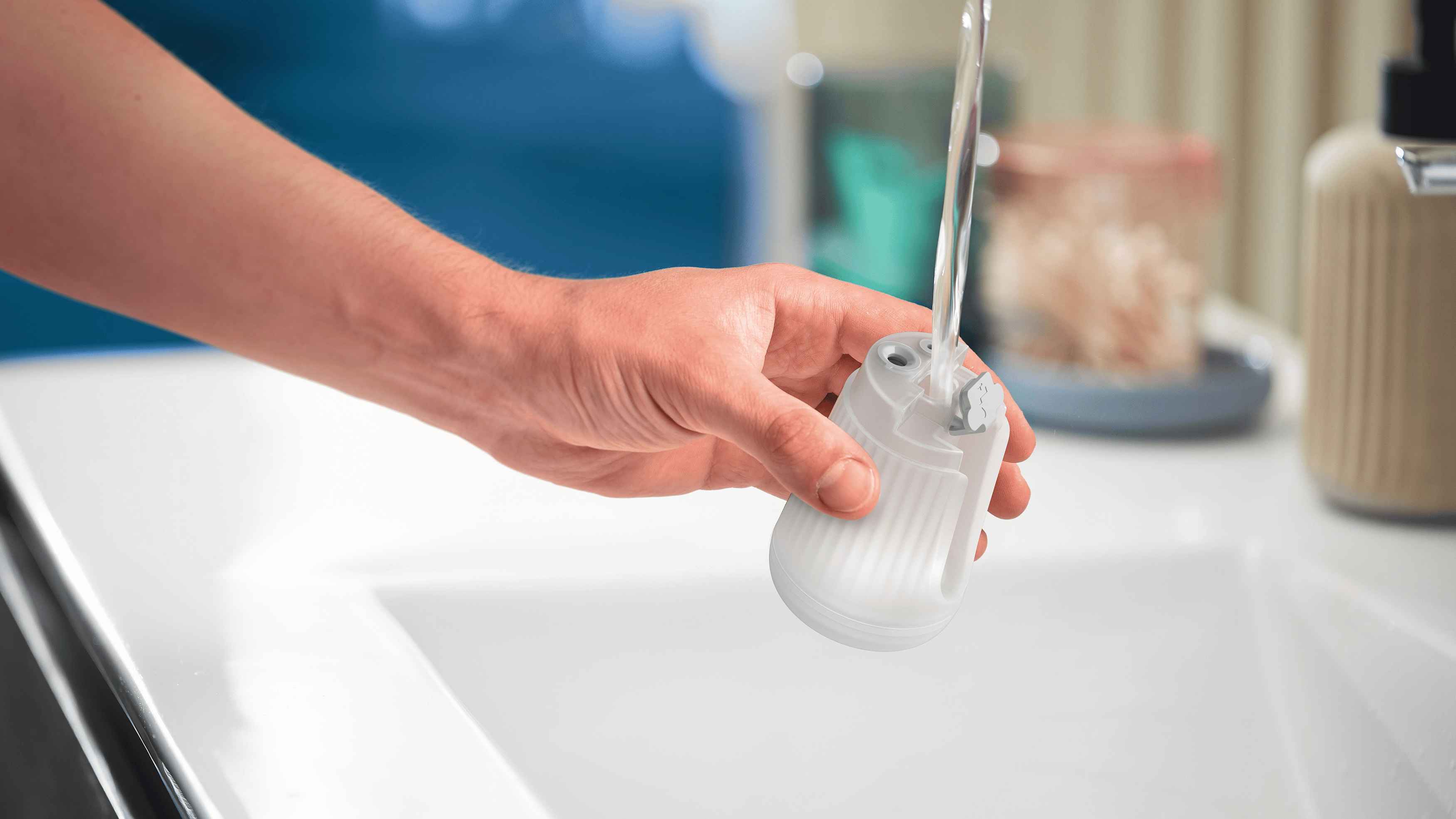 Befüllen des transparenten Wasserbehälters eines Philips Handdampfgarers unter fließendem Wasser, um das praktische Design hervorzuheben. Befüllen des transparenten Wasserbehälters eines Philips Handdampfgarers unter fließendem Wasser, um das praktische Design hervorzuheben.