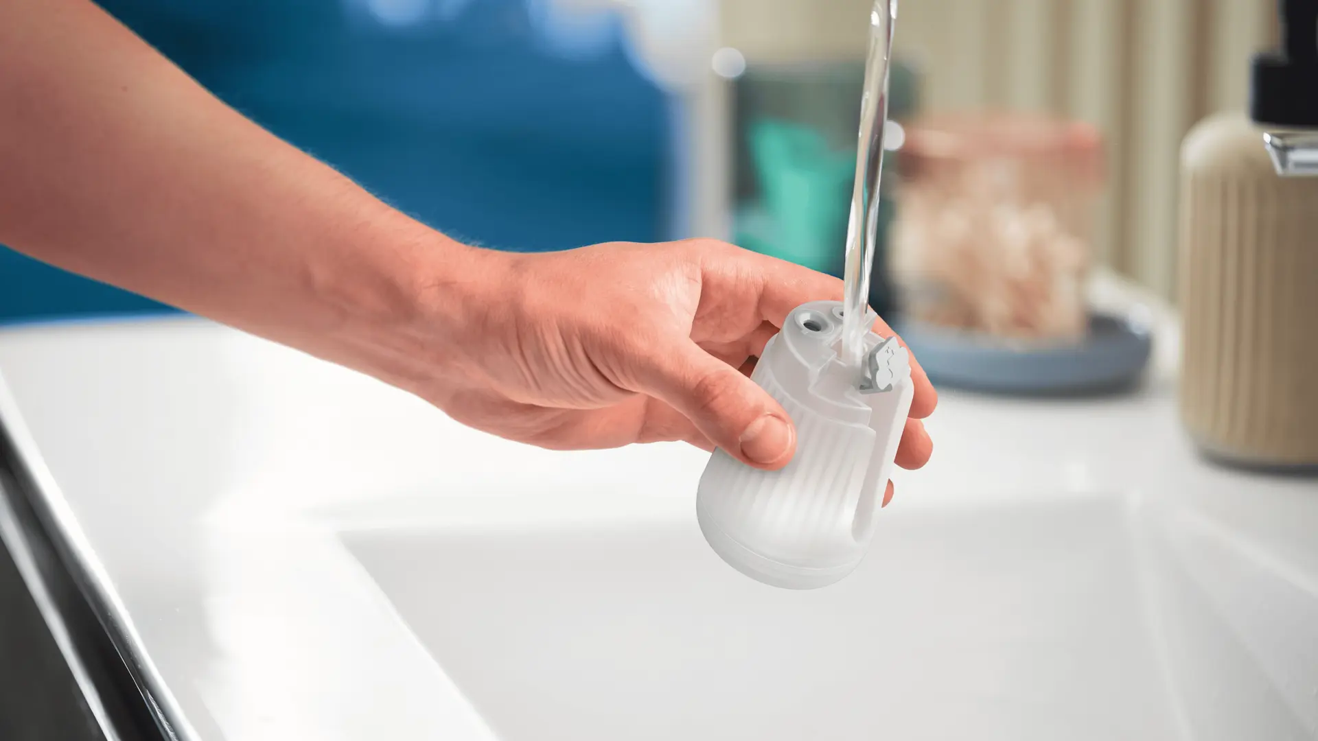 Ręczne napełnianie przezroczystego zbiornika na wodę parownicy Philips pod bieżącą wodą, podkreślając wygodną konstrukcję parownicy. Ręczne napełnianie przezroczystego zbiornika na wodę parownicy Philips pod bieżącą wodą, podkreślając wygodną konstrukcję parownicy.