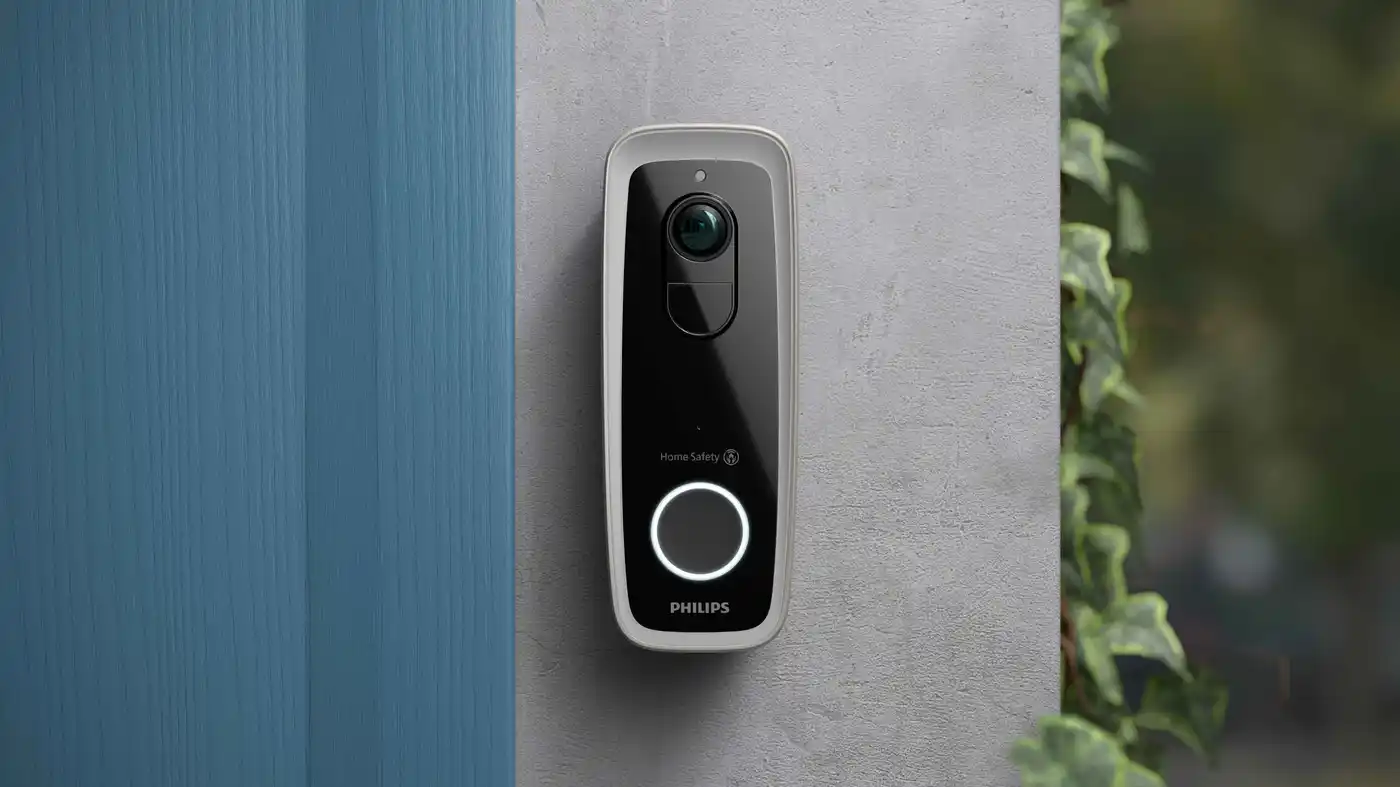 Videozvonek Philips Home Safety, zachycuje jasné snímky pomocí vestavěné kamery a notifikačního tlačítka, namontovaný na zdi, zobrazuje bezpečnostní řešení značky. Videozvonek Philips Home Safety, zachycuje jasné snímky pomocí vestavěné kamery a notifikačního tlačítka, namontovaný na zdi, zobrazuje bezpečnostní řešení značky.