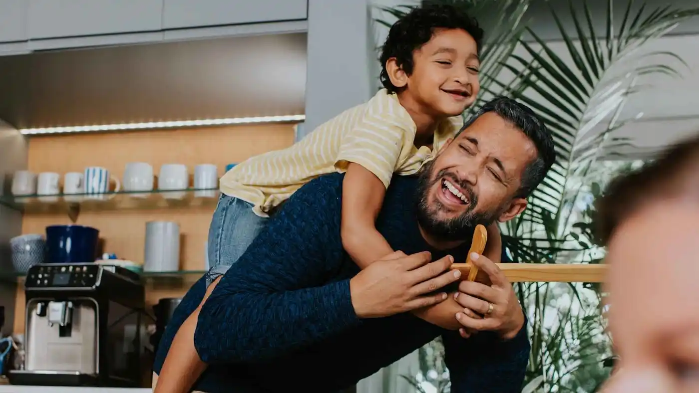 Glücklicher Vater und Sohn lachen bei einem Huckepack-Ritt zu Hause. Diese Philips Szene zeigt, wie unsere Produkte, z.B. die Kaffeemaschine, das Familienwohlbefinden unterstützen. Glücklicher Vater und Sohn lachen bei einem Huckepack-Ritt zu Hause. Diese Philips Szene zeigt, wie unsere Produkte, z.B. die Kaffeemaschine, das Familienwohlbefinden unterstützen.