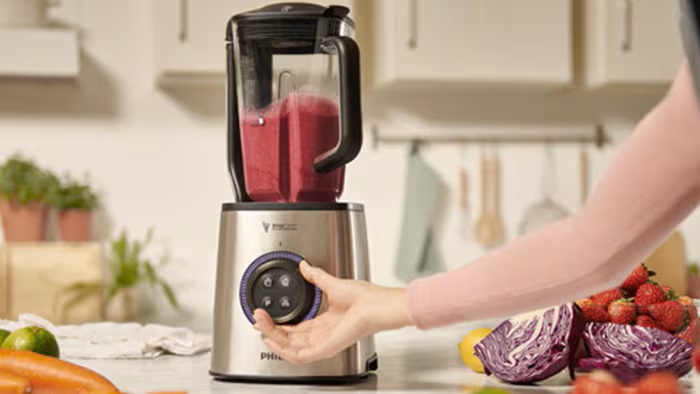 O persoană amestecă ingredientele într-un blender pentru a prepara un smoothie într-o bucătărie luminoasă. O persoană amestecă ingredientele într-un blender pentru a prepara un smoothie într-o bucătărie luminoasă.