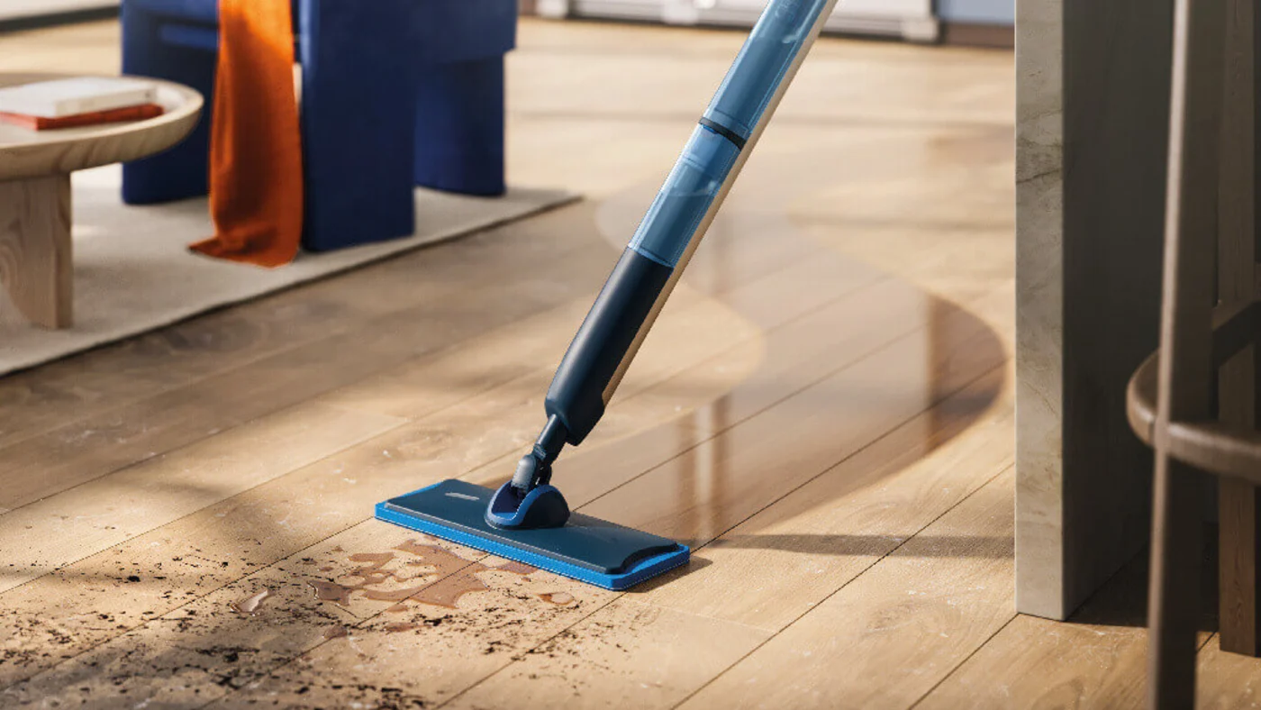 Niebiesko-czarny mop elektryczny marki Philips aktywnie czyści zabrudzone panele podłogowe. Niebiesko-czarny mop elektryczny marki Philips aktywnie czyści zabrudzone panele podłogowe.