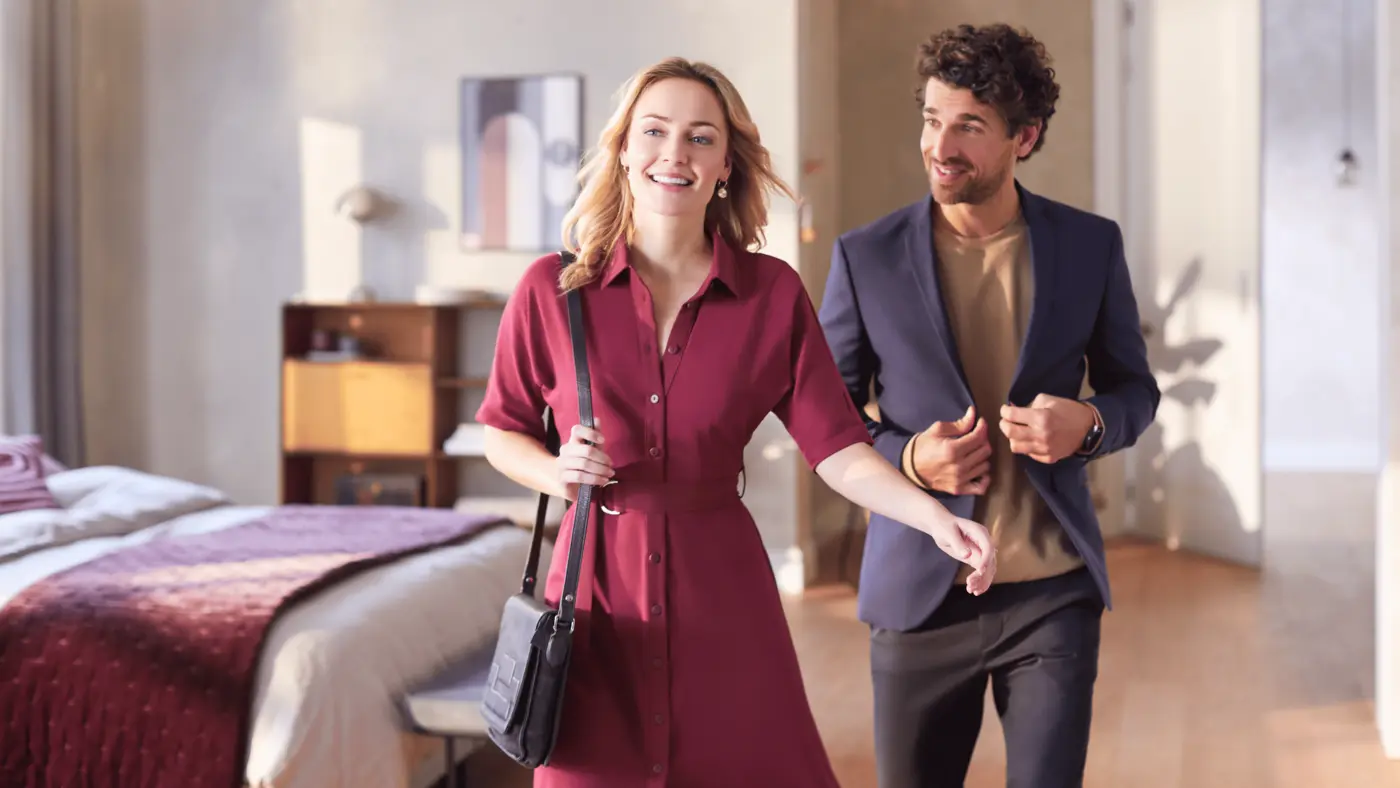 Couple souriant avec des vêtements fraîchement défroissés, mettant en évidence les résultats du repassage avec la centrale vapeur Philips PerfectCare série 8000. Couple souriant avec des vêtements fraîchement défroissés, mettant en évidence les résultats du repassage avec la centrale vapeur Philips PerfectCare série 8000.