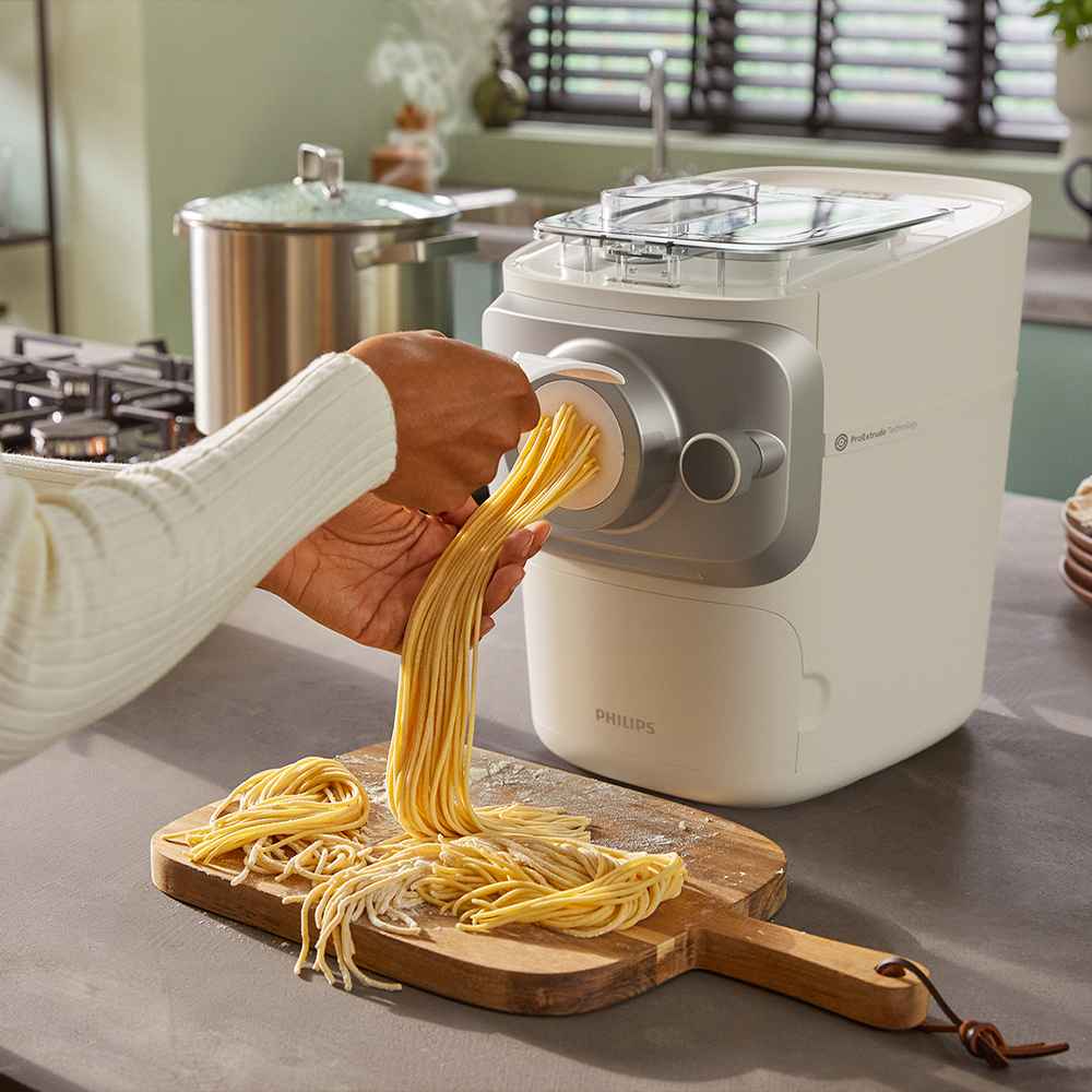 Przegląd świeżych kreacji Philips Pasta Maker. Miski i talerze prezentują żywy makaron wokół napisu "PASTA" ułożonego z mąki. Matryce Philips sugerują doskonałe domowe wrażenia. Przegląd świeżych kreacji Philips Pasta Maker. Miski i talerze prezentują żywy makaron wokół napisu "PASTA" ułożonego z mąki. Matryce Philips sugerują doskonałe domowe wrażenia.