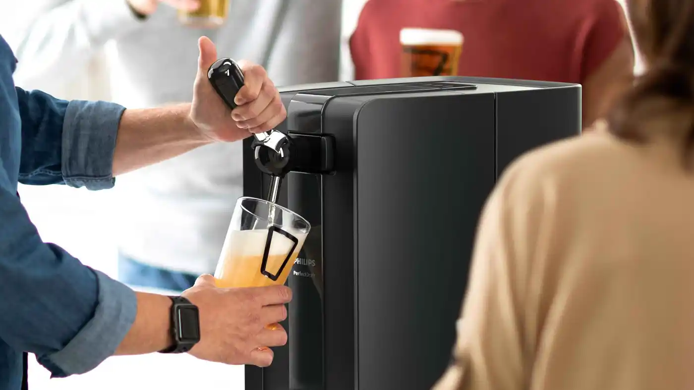 Close-up of a Philips Perfect Draft beer dispenser pouring a pint, showcasing its advanced technology for perfectly chilled and carbonated beer at home. Close-up of a Philips Perfect Draft beer dispenser pouring a pint, showcasing its advanced technology for perfectly chilled and carbonated beer at home.