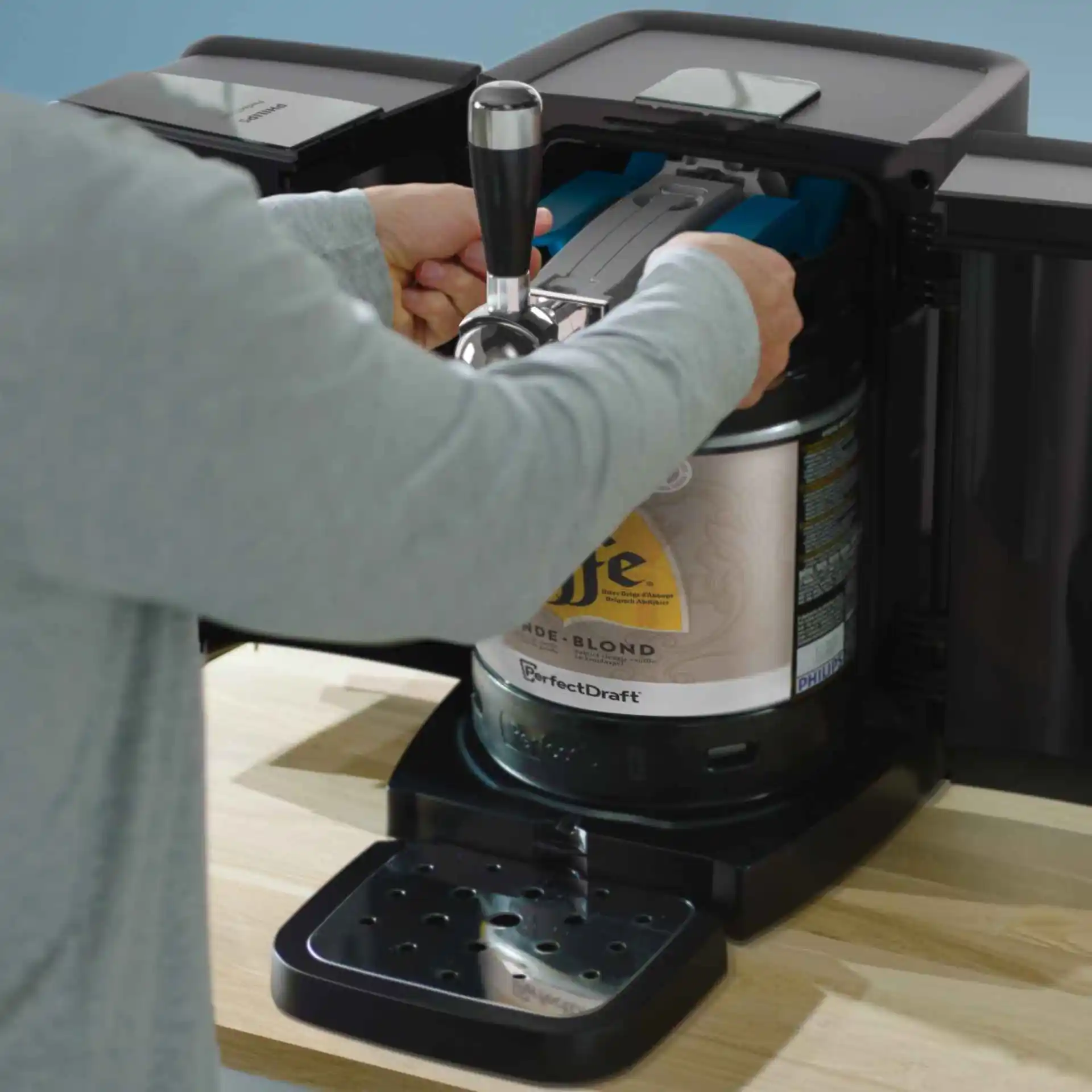 En person som lastar en ölfat i en Philips Perfect Draft öltapp, vilket säkerställer en konsekvent kyld, perfekt upphälld ölupplevelse hemma. En person som lastar en ölfat i en Philips Perfect Draft öltapp, vilket säkerställer en konsekvent kyld, perfekt upphälld ölupplevelse hemma.