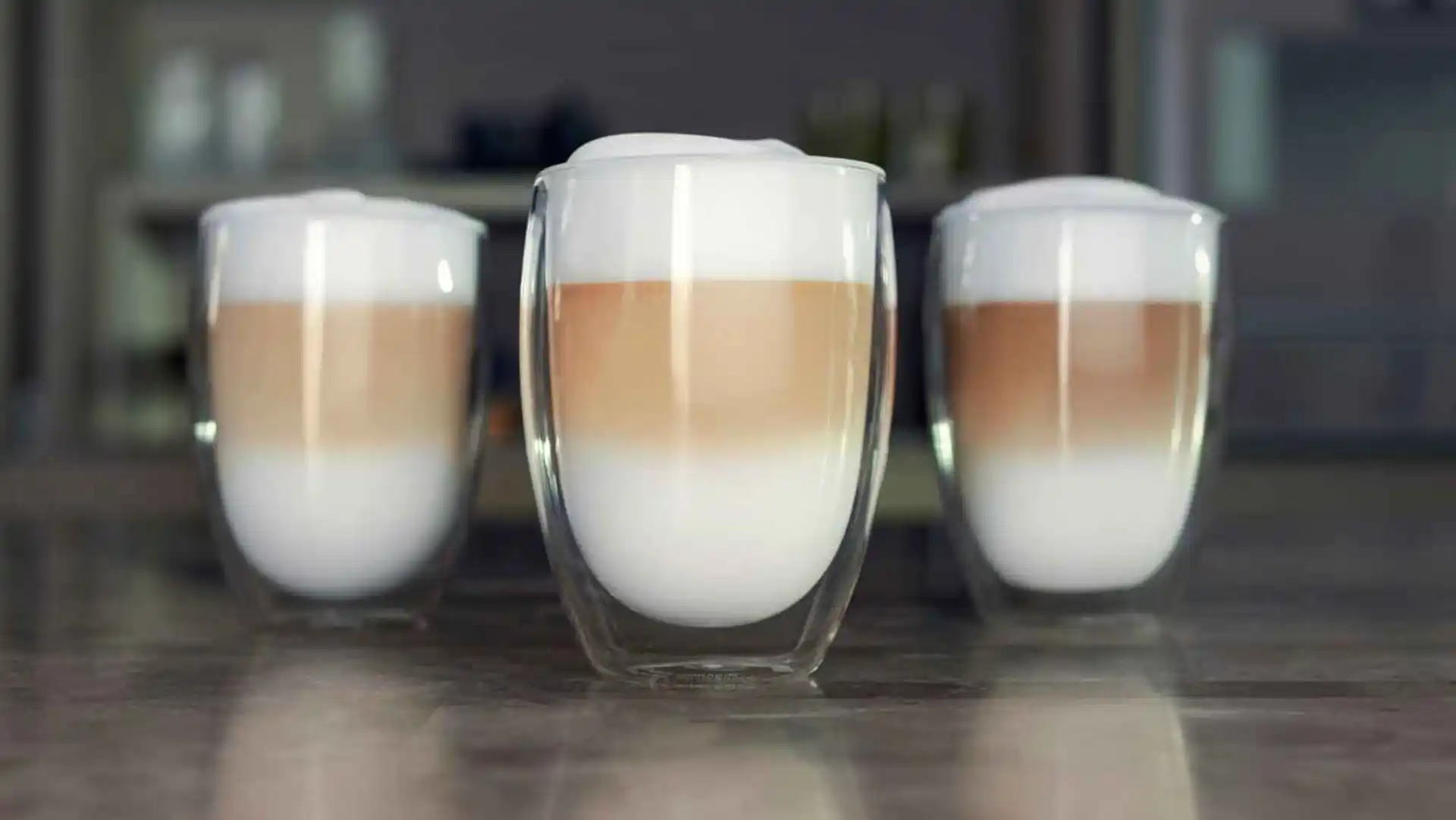 Three layered coffee lattes prepared with a Philips Saeco machine, served in clear, double-walled glasses, highlighting the layers and quality of the brew. Three layered coffee lattes prepared with a Philips Saeco machine, served in clear, double-walled glasses, highlighting the layers and quality of the brew.