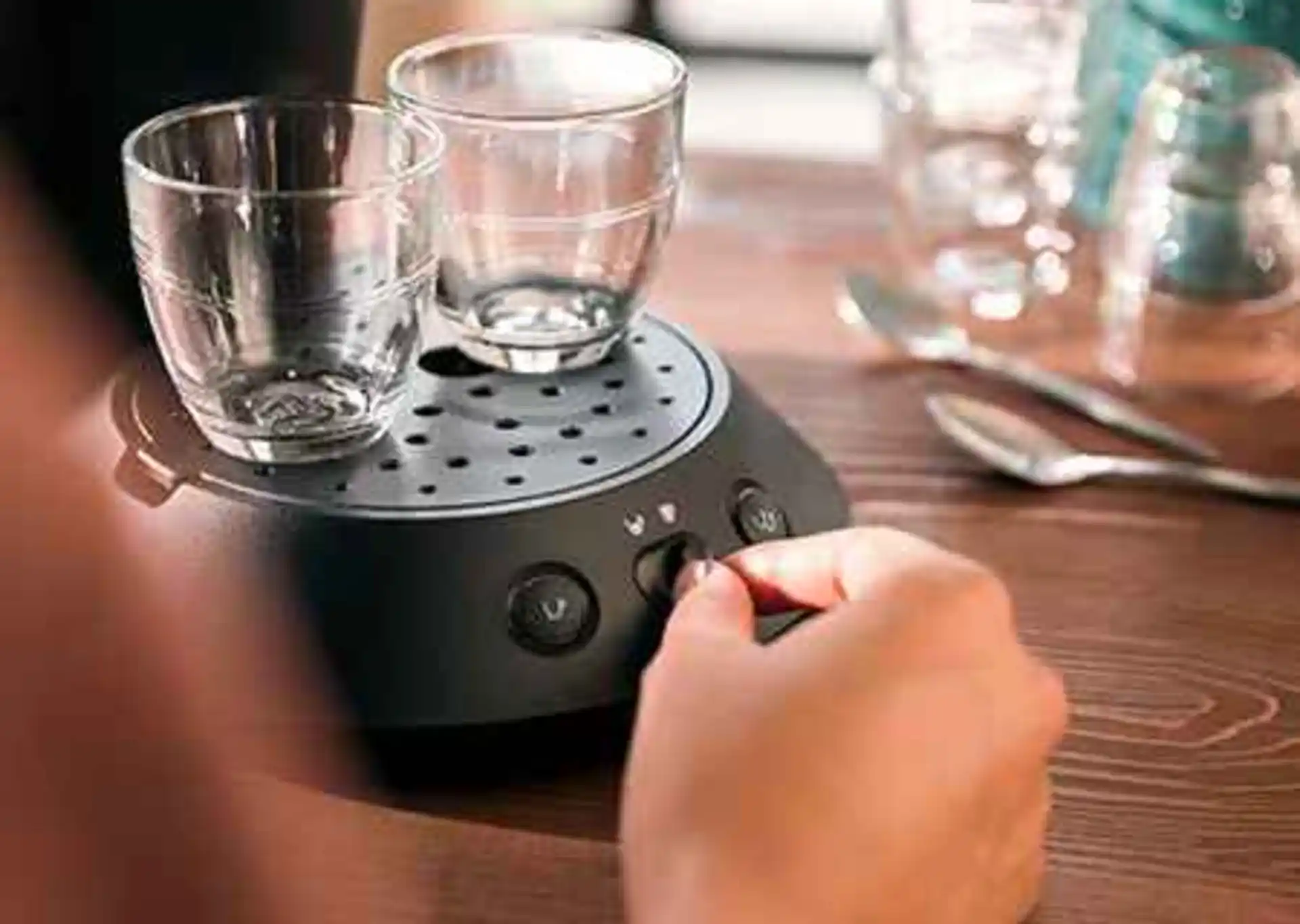 Close-up of a Philips Senseo coffee machine warming two glasses, ready for pod coffee. Features user-friendly controls and a stylish countertop presence. Close-up of a Philips Senseo coffee machine warming two glasses, ready for pod coffee. Features user-friendly controls and a stylish countertop presence.