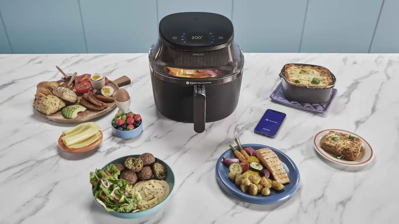 Philips Airfryer with various healthy dishes and HomeID app on marble kitchen counter. Philips Airfryer with various healthy dishes and HomeID app on marble kitchen counter.