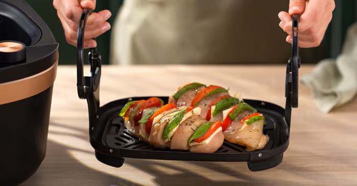 Pasar las pechugas de pollo rellenas a la bandeja inferior. Pasar las pechugas de pollo rellenas a la bandeja inferior.