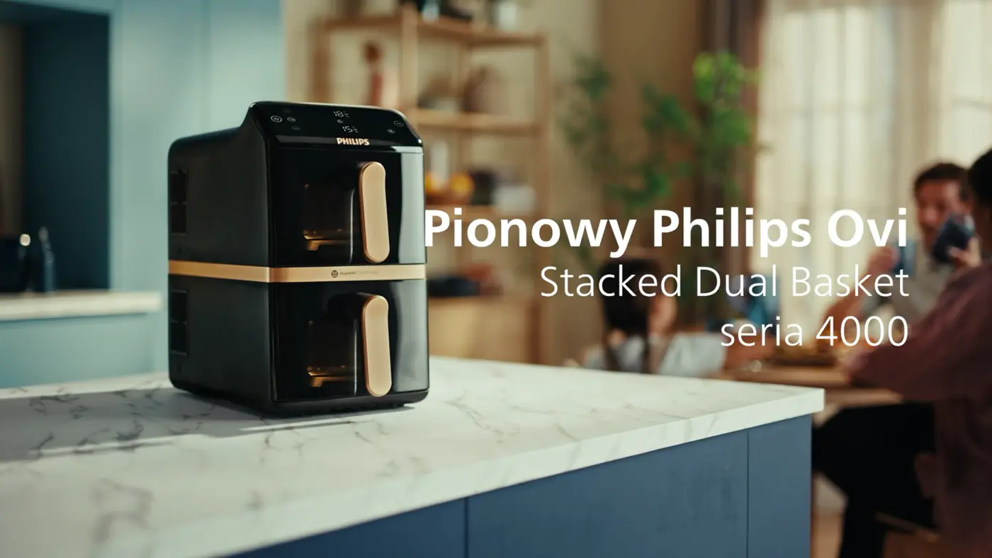 Airfryer Philips Ovi z podwójnym, pionowym koszem z serii 4000, stojący na blacie kuchennym. W tle rozmyta scena rodziny jedzącej posiłek przy stole. Airfryer Philips Ovi z podwójnym, pionowym koszem z serii 4000, stojący na blacie kuchennym. W tle rozmyta scena rodziny jedzącej posiłek przy stole.