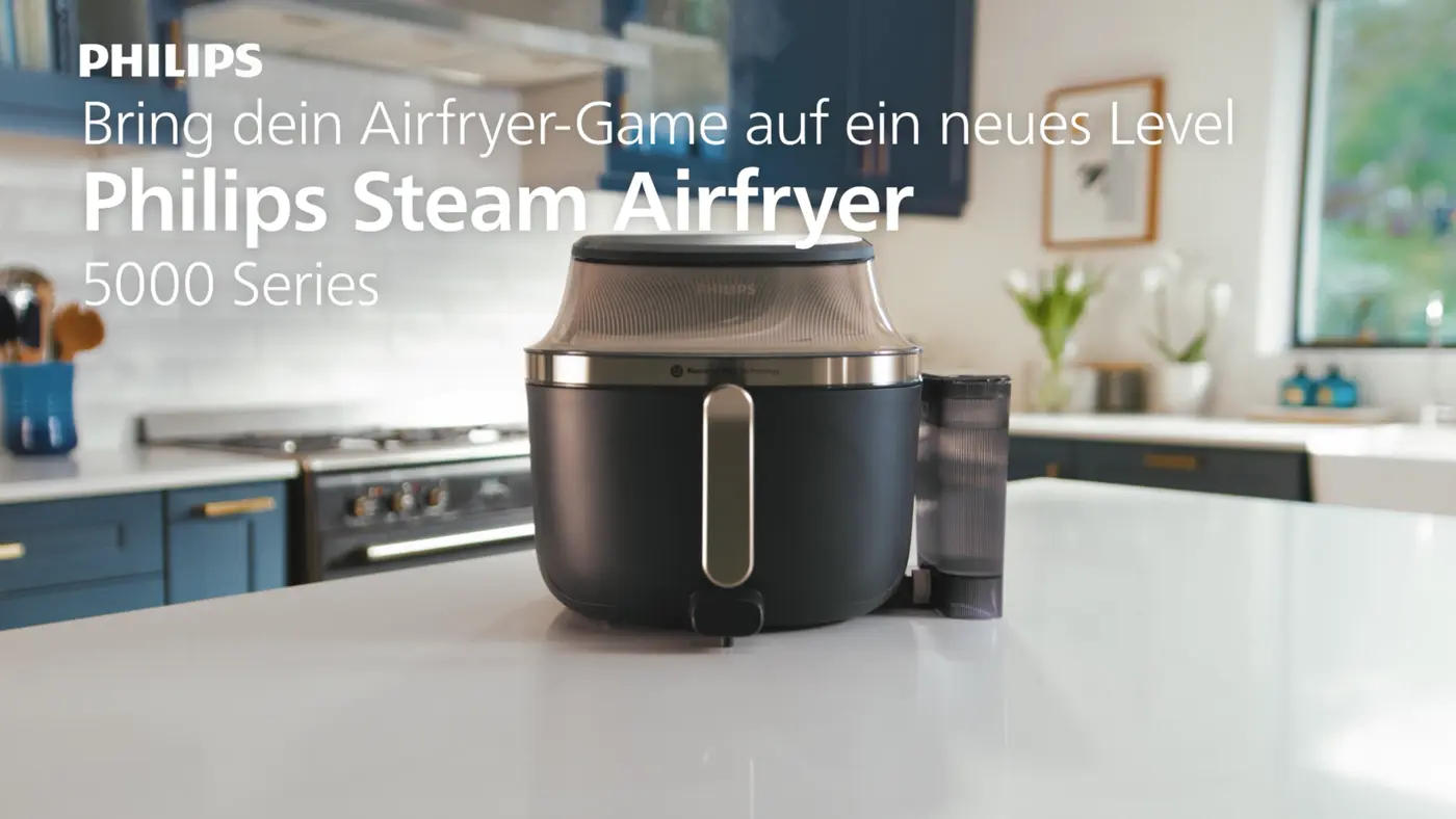 Philips Airfryer mit Dampf 5000 Series auf der Küchentheke mit Text 'Entdecken Sie eine Welt voller Aromen' und 'Besuchen Sie philips.com für mehr'. Philips Airfryer mit Dampf 5000 Series auf der Küchentheke mit Text 'Entdecken Sie eine Welt voller Aromen' und 'Besuchen Sie philips.com für mehr'.