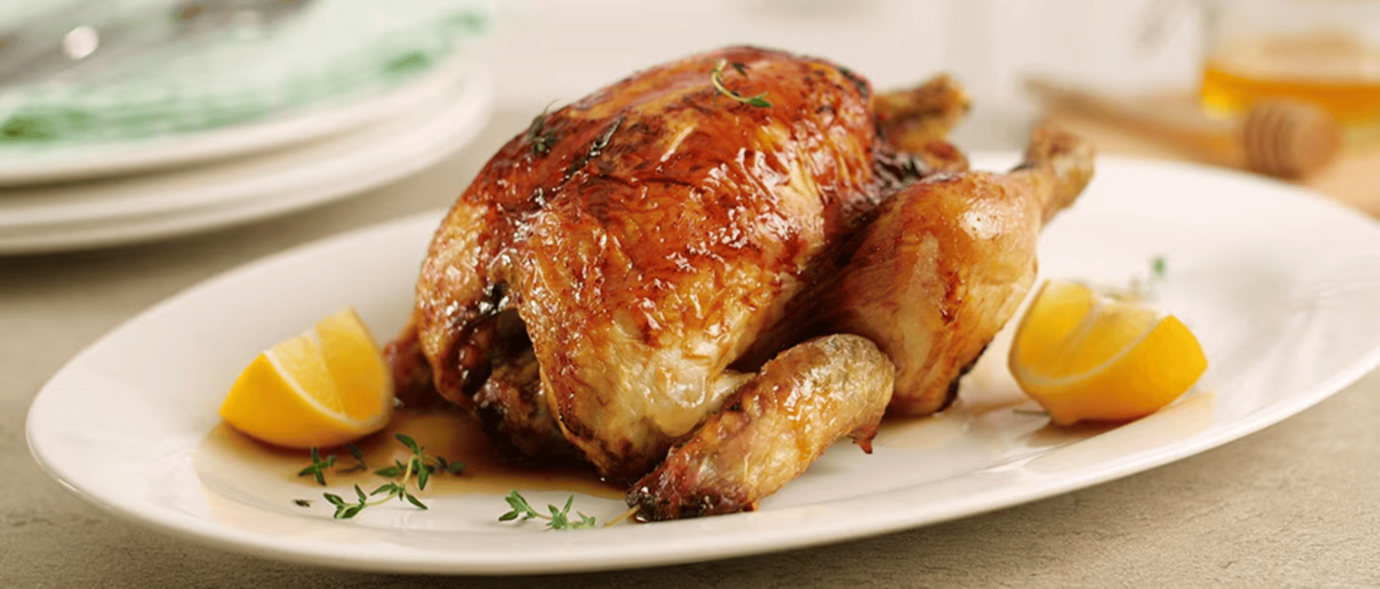 Airfryer-opskrift Kylling. Et lækkert billede af en helstegt kylling serveret på en hvid tallerken, garnéret med citron og krydderurter, der indbyder til kulinariske oplevelser. Airfryer-opskrift Kylling. Et lækkert billede af en helstegt kylling serveret på en hvid tallerken, garnéret med citron og krydderurter, der indbyder til kulinariske oplevelser.