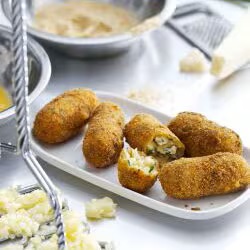 A plate of golden potato croquettes with melted Parmesan cheese A plate of golden potato croquettes with melted Parmesan cheese